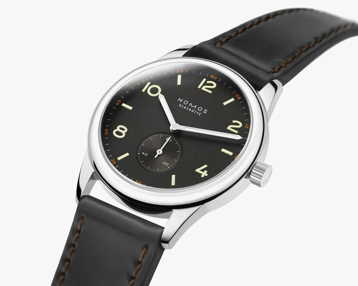 NOMOS Glashütte wristwatch featuring a black dial, silver-tone numerals, and a black leather strap.