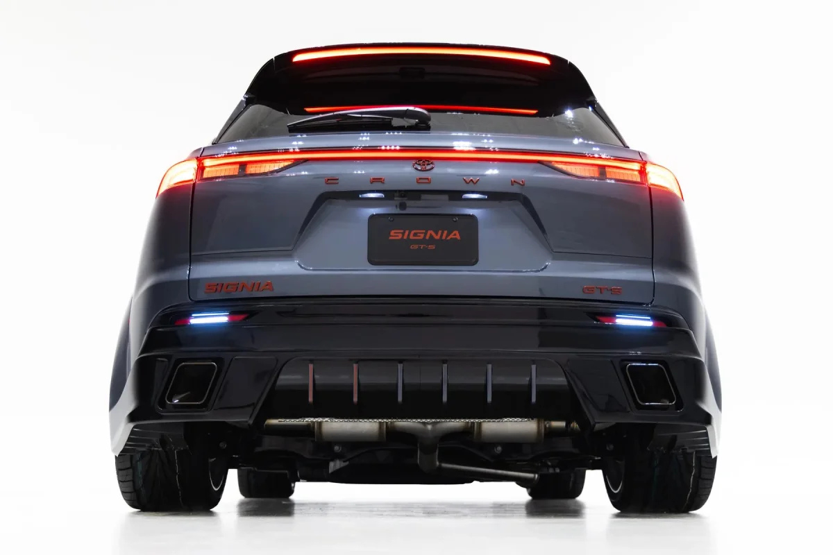Rear view of a grey Toyota Crown Signia SUV featuring illuminated red taillights and dual exhaust pipes.