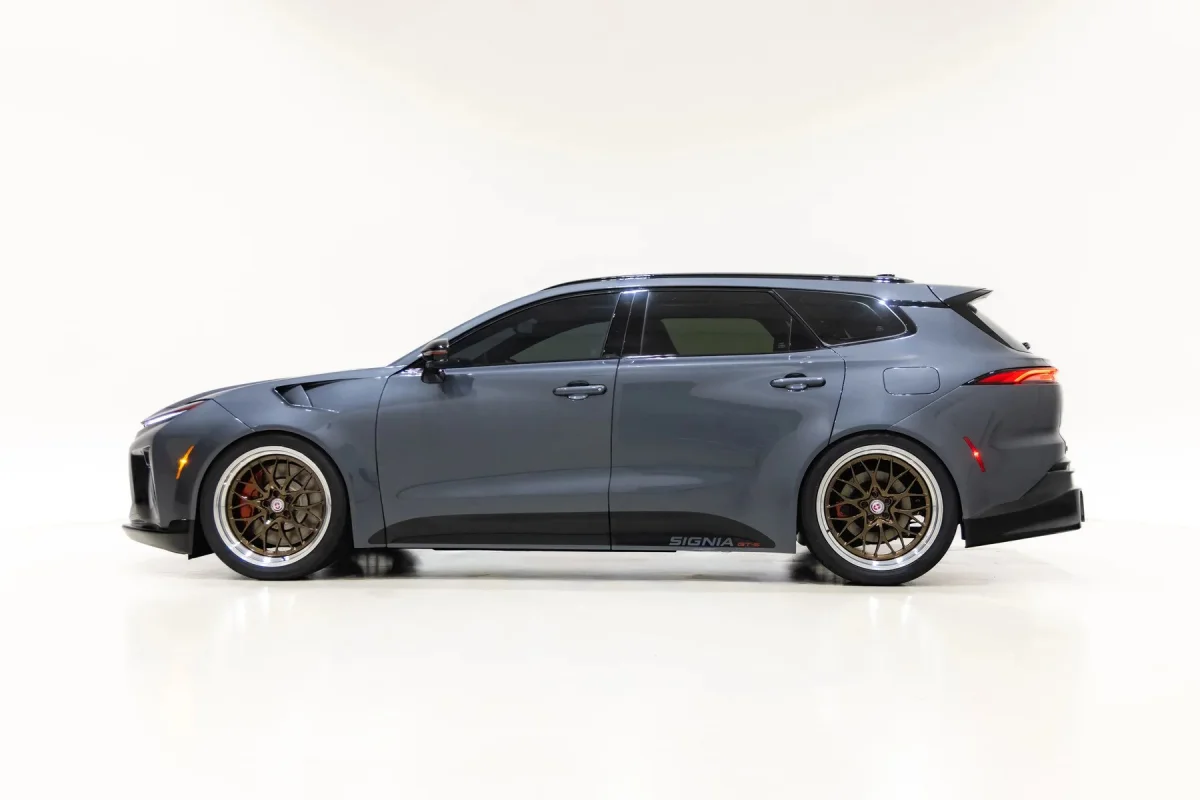 Side profile of a gray station wagon with bronze multi-spoke wheels and tinted windows.