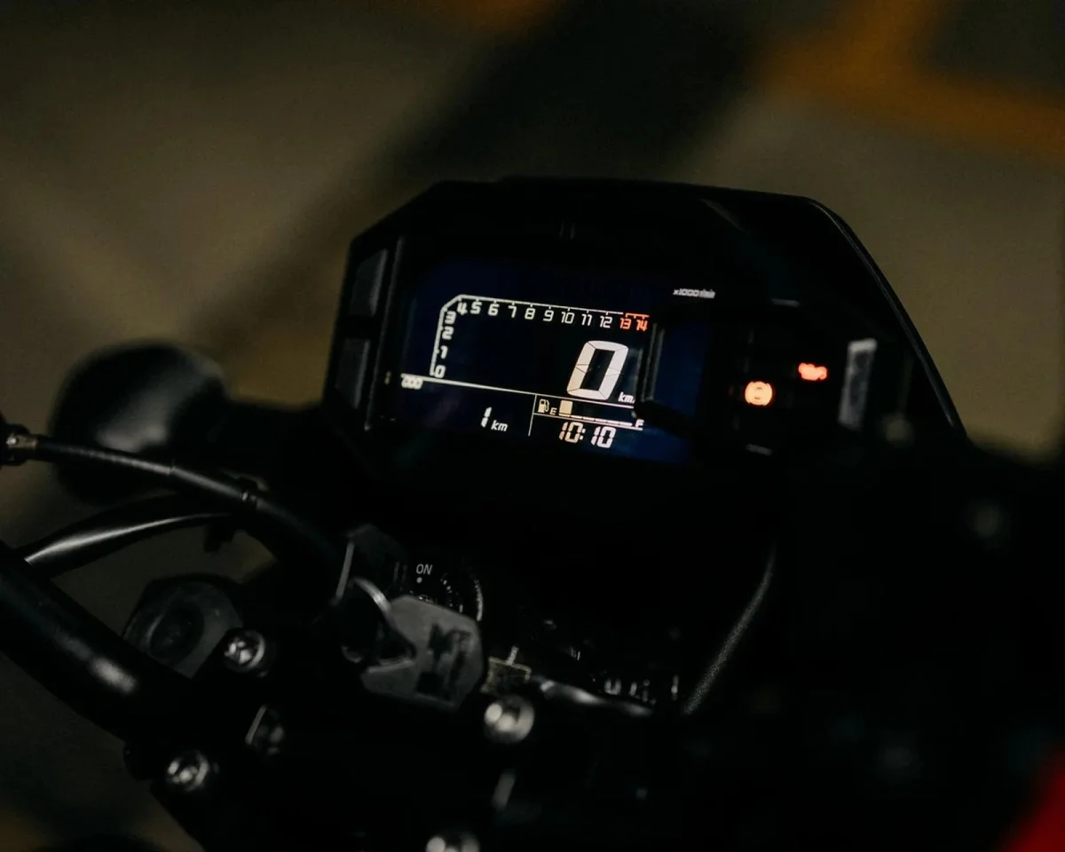Digital motorcycle dashboard displaying a speed of zero, a clock reading 10:10, and a fuel gauge.