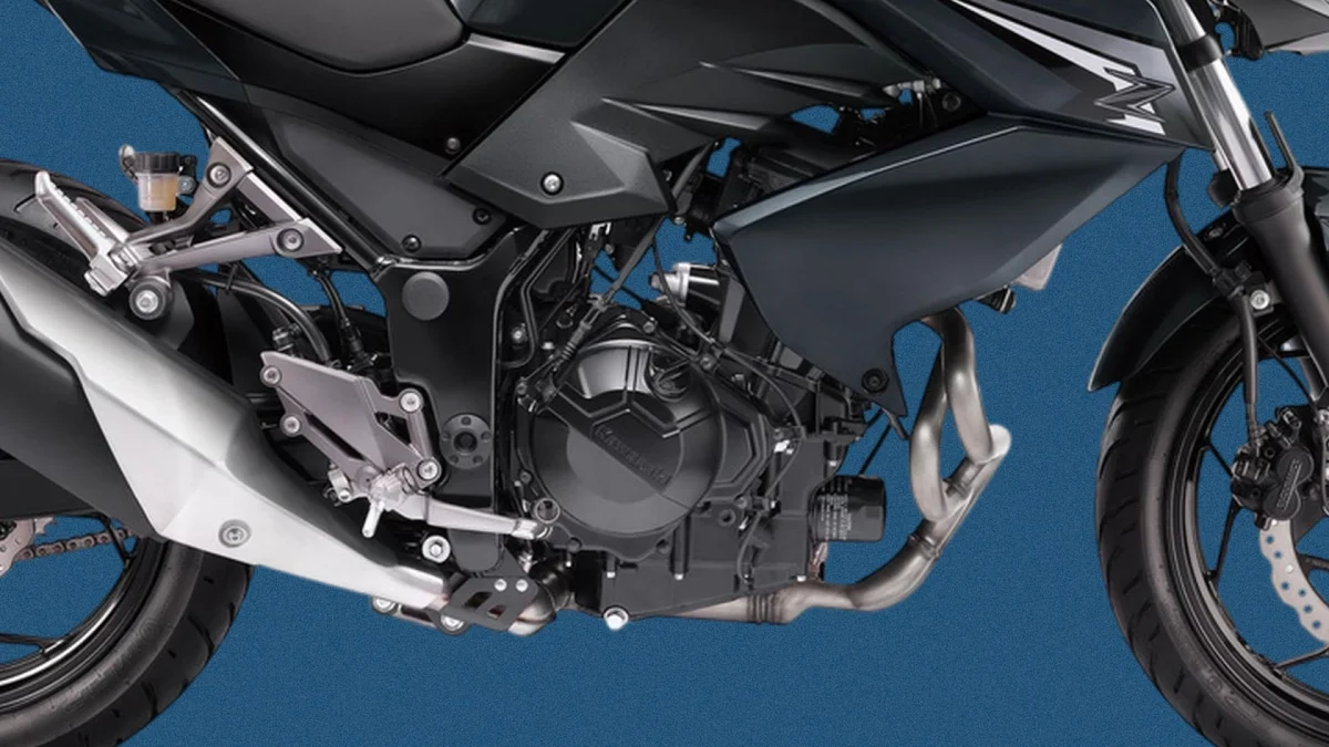 Close-up of a black Kawasaki motorcycle engine, frame, and front wheel.