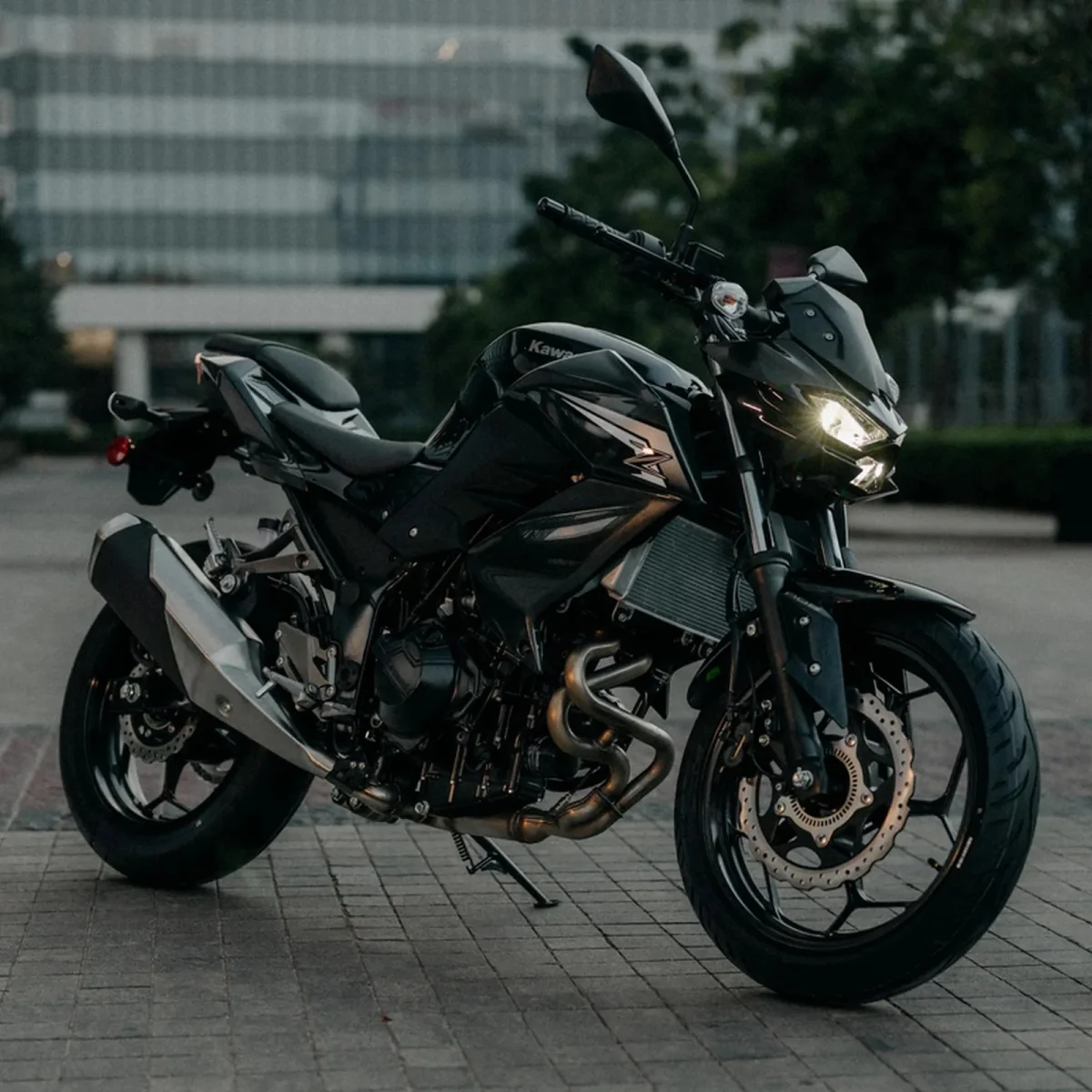Black Kawasaki naked sport motorcycle parked on a paved plaza.