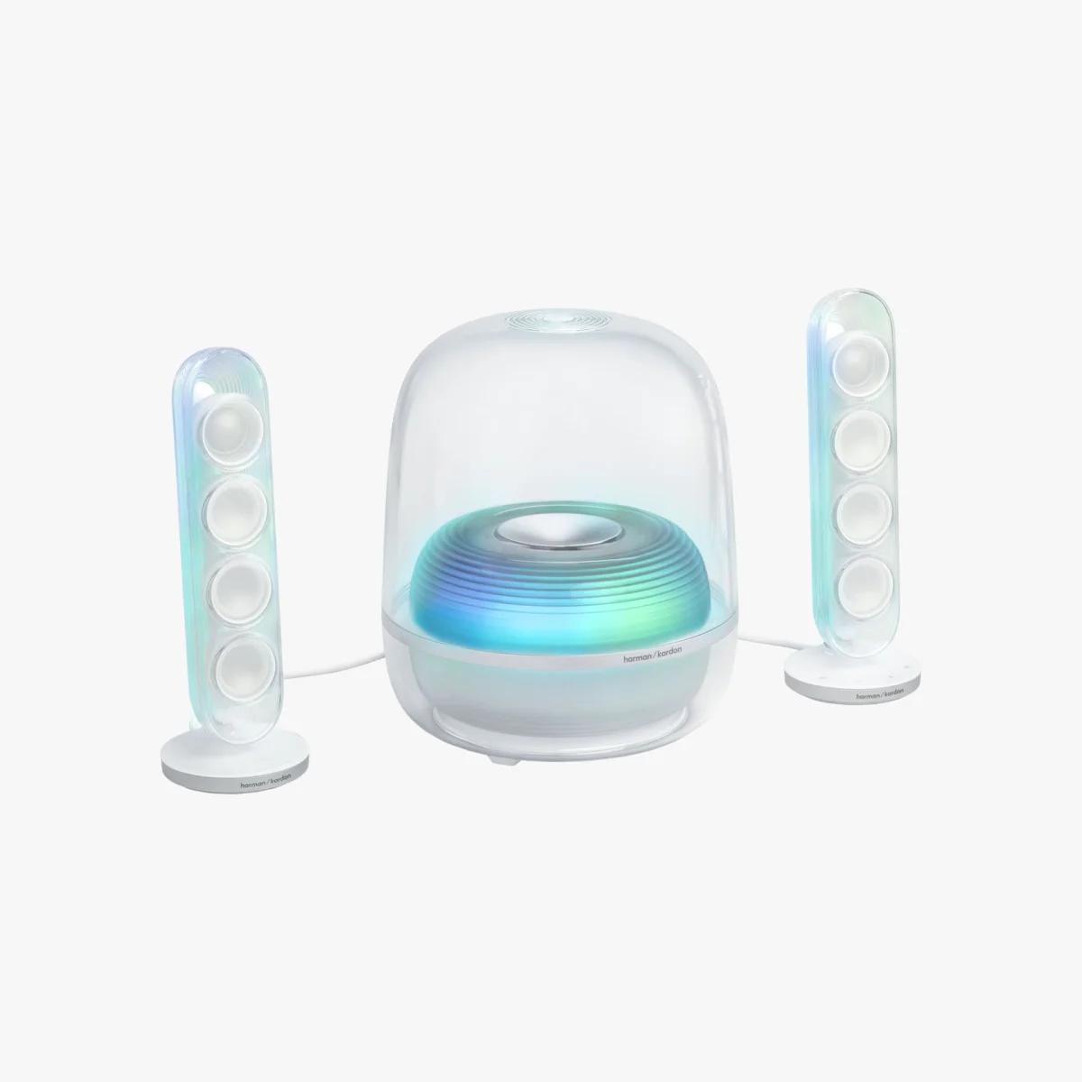 Transparent Harman Kardon speaker system with blue-green glowing subwoofer and two vertical satellite speakers.