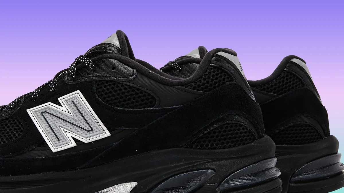 Pair of black New Balance sneakers with mesh and suede panels and reflective silver detailing.