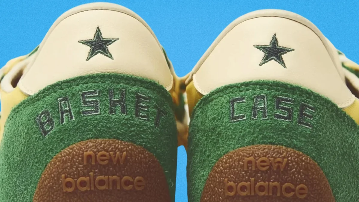 Close-up of green and cream New Balance sneakers with embroidered black stars.