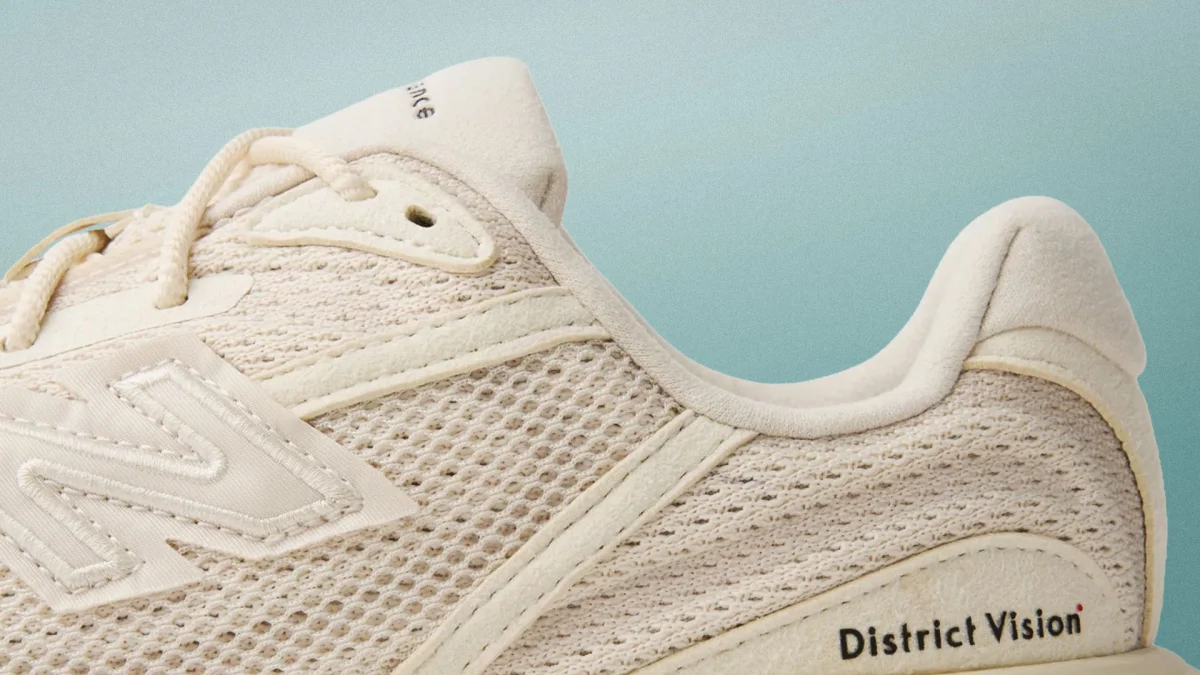Close-up of beige New Balance sneaker with mesh upper.