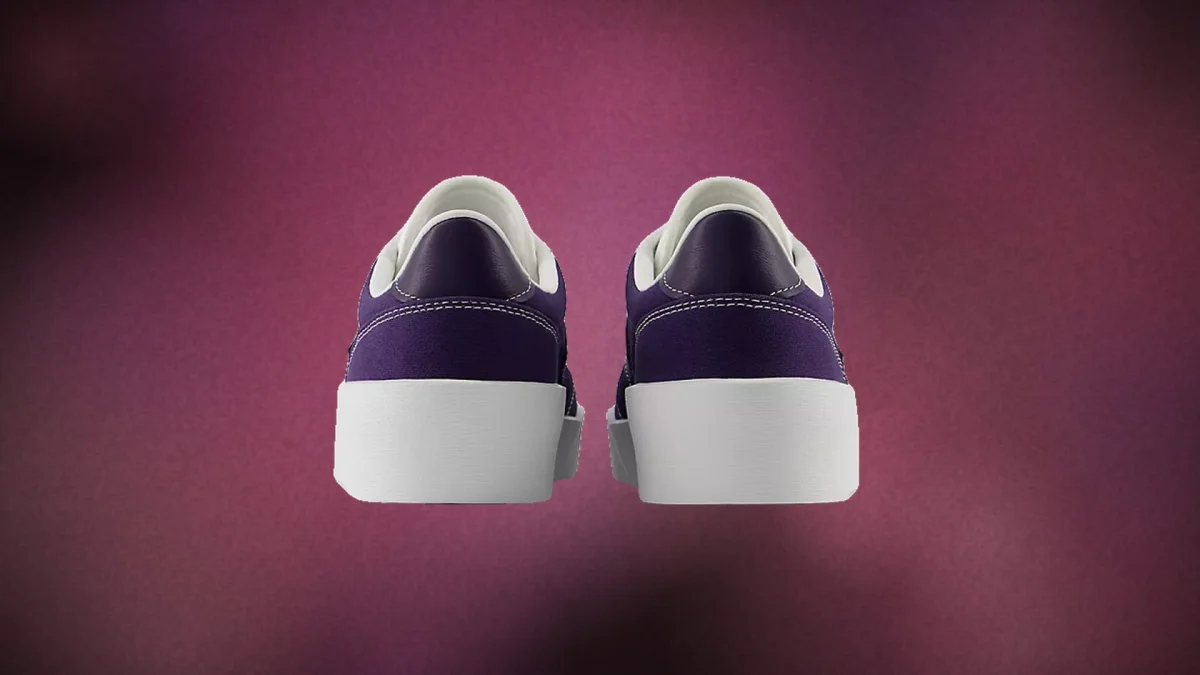 Pair of purple sneakers with white soles shown from the back against a purple background.