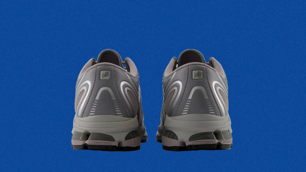 Back view of grey New Balance athletic sneakers featuring reflective detailing.