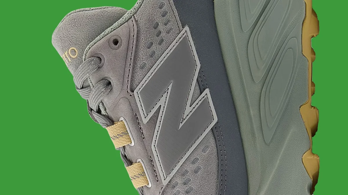 Gray and olive New Balance sneaker with textured sole.