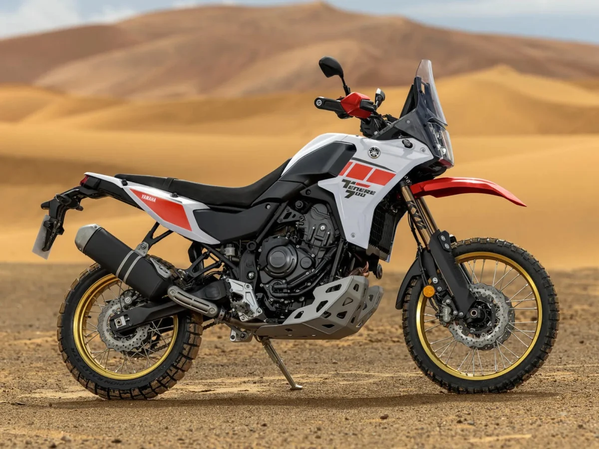 Yamaha Tenere 700 adventure motorcycle in white, red, and black, parked in a desert landscape.