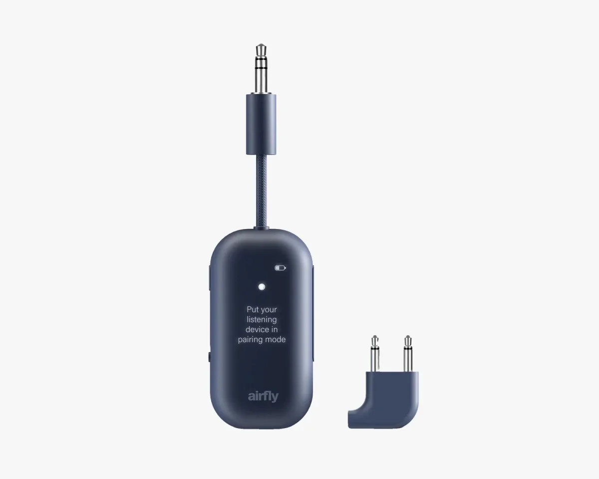 Twelve South AirFly wireless transmitter, featuring a compact rectangular shape with a matte finish, shown with an attached 3.5mm cable and a separate dual-prong airplane headphone adapter.
