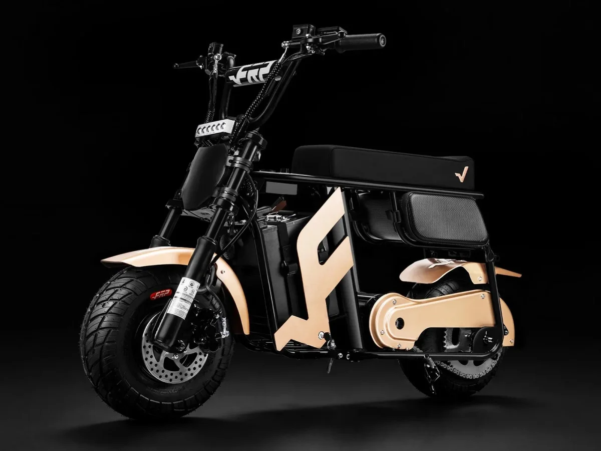 Electric moped with a black frame, gold-colored fenders and side panels, a flat black seat, and thick tires.