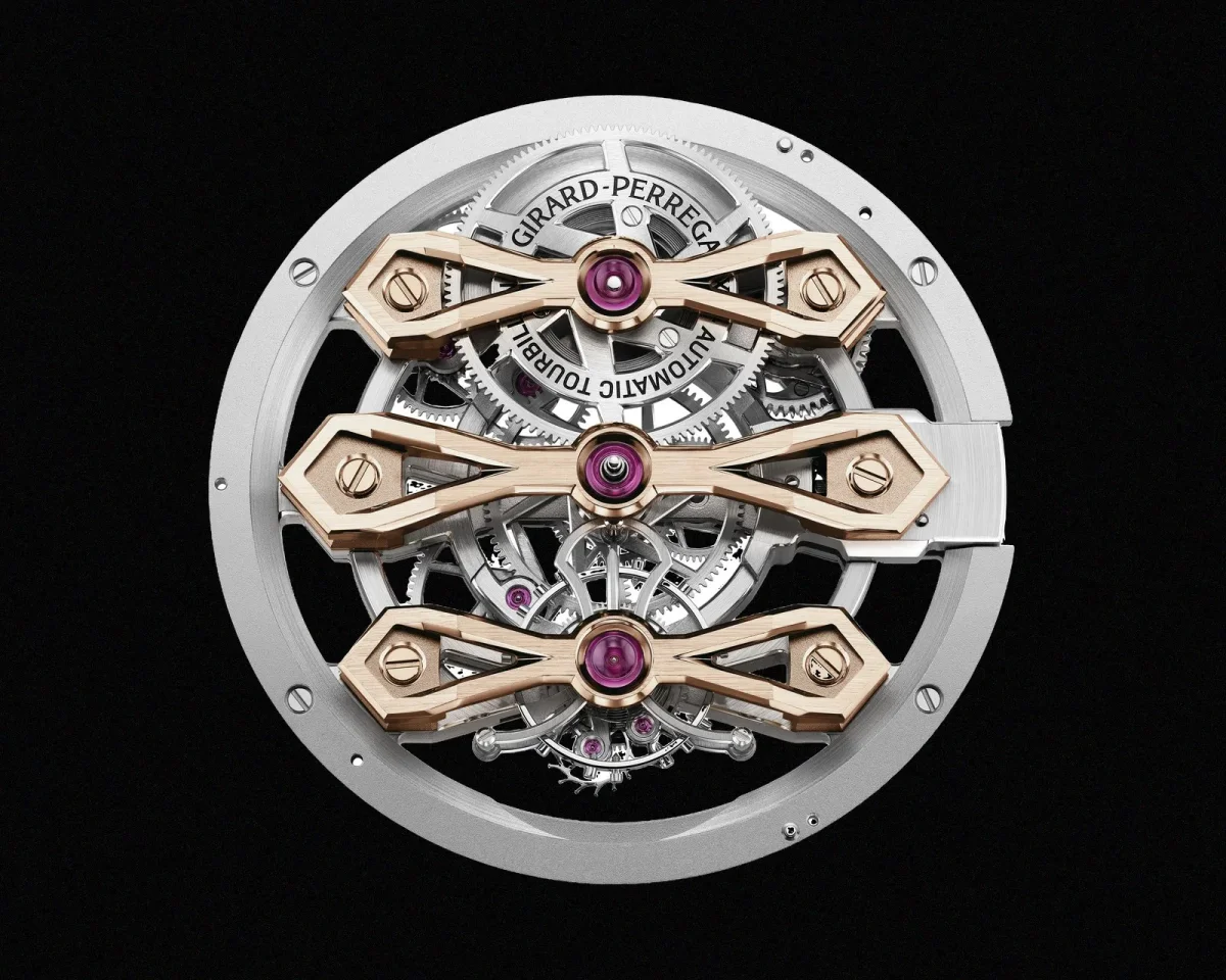 Girard-Perregaux tourbillon watch movement featuring three horizontal rose gold bridges over a silver mechanism with visible gears and ruby jewels.