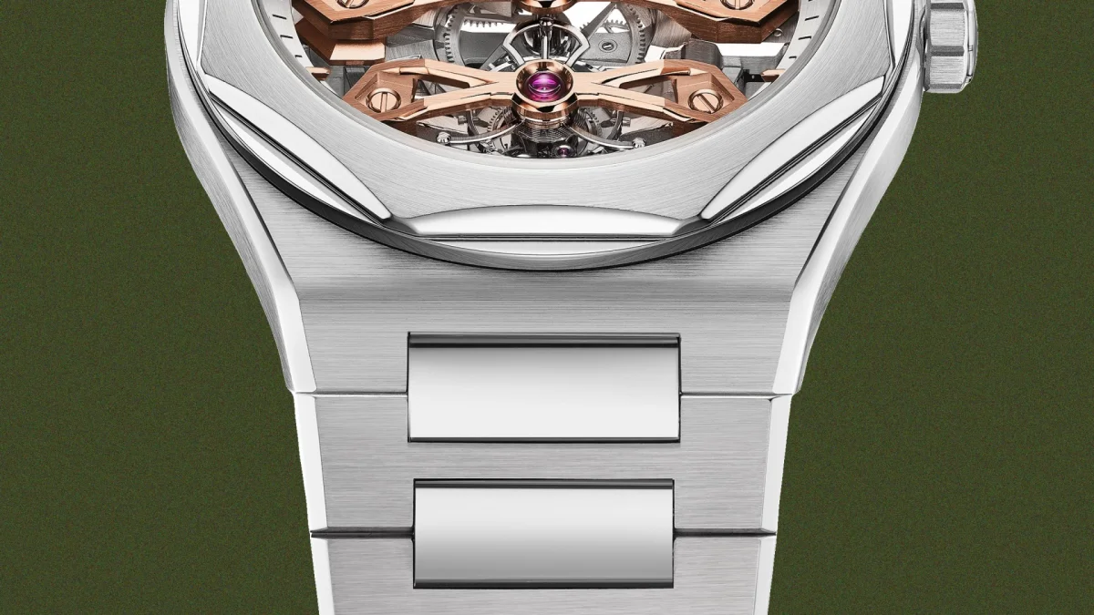 Close-up of a silver-toned wristwatch with a skeletonized dial, featuring rose-gold mechanical components and a brushed metal bracelet.