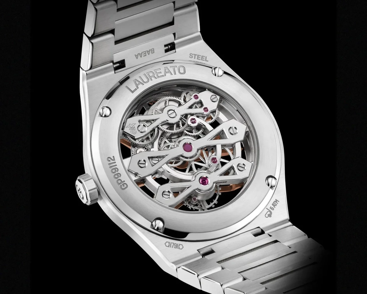 Exhibition case back of a Girard-Perregaux Laureato watch, featuring a visible mechanical movement, a steel bracelet, and case back engravings including LAUREATO, STEEL, and GP99112.