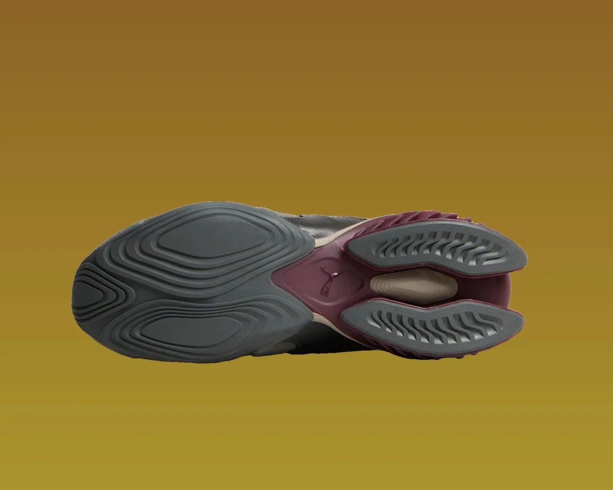 Dark grey sneaker outsole featuring a burgundy sculpted heel and a small Puma logo.