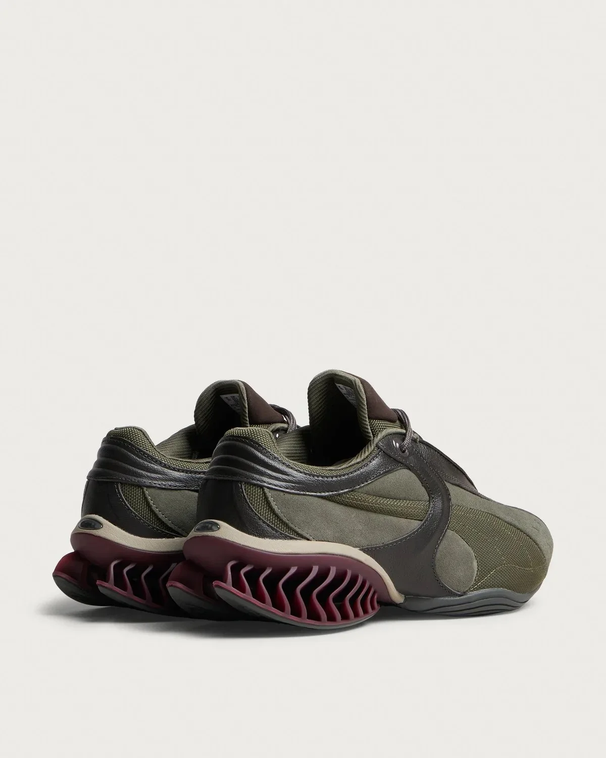 Olive green and brown low-top sneakers featuring a structural maroon midsole.