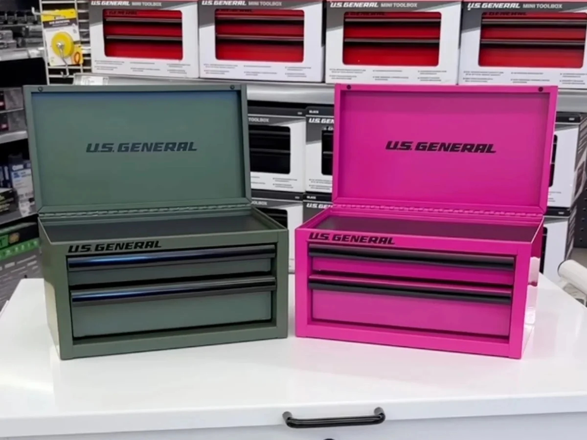 Olive green and bright pink U.S. General mini toolboxes with open lids resting on a white counter.