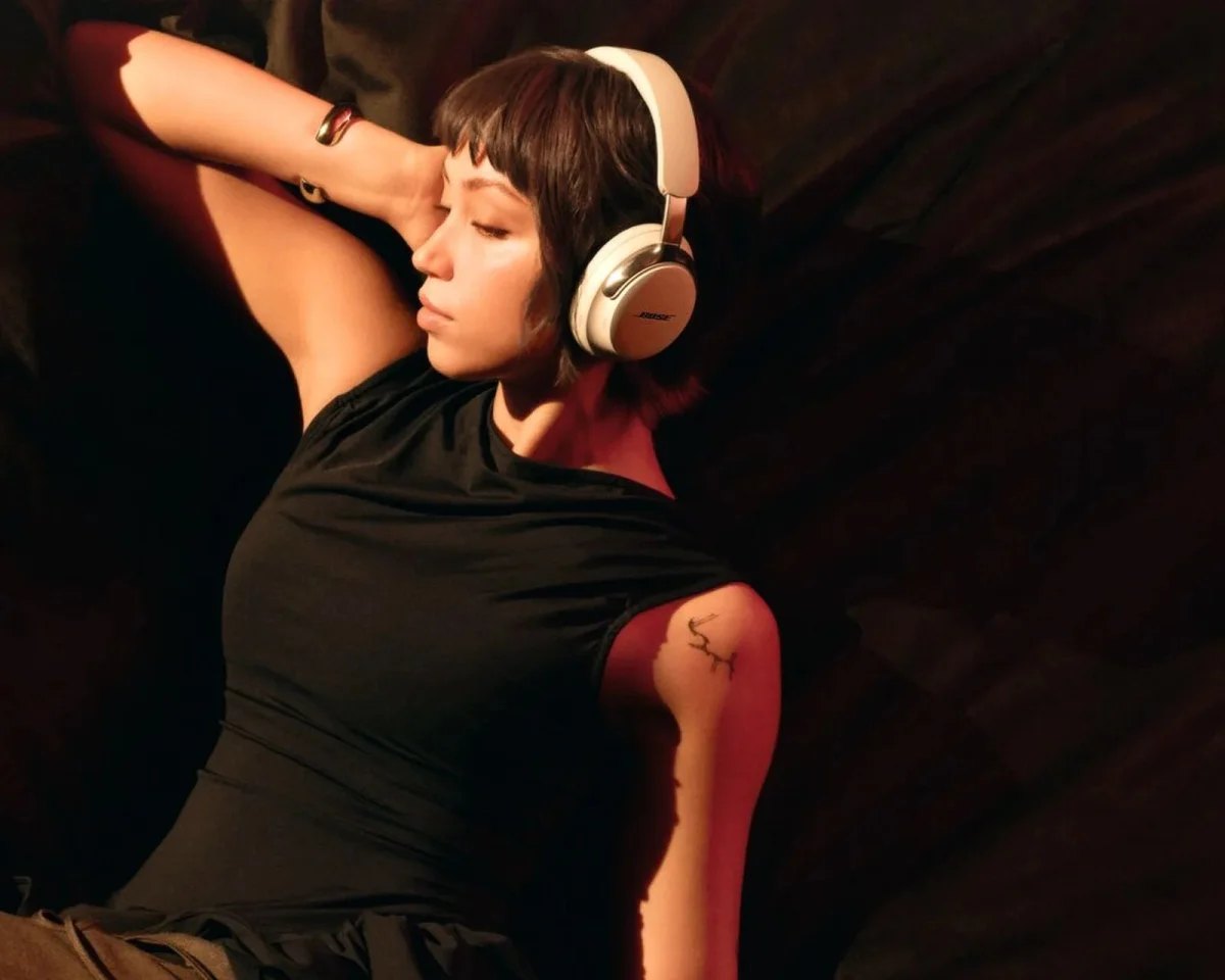 White Bose over-ear headphones worn while reclining.