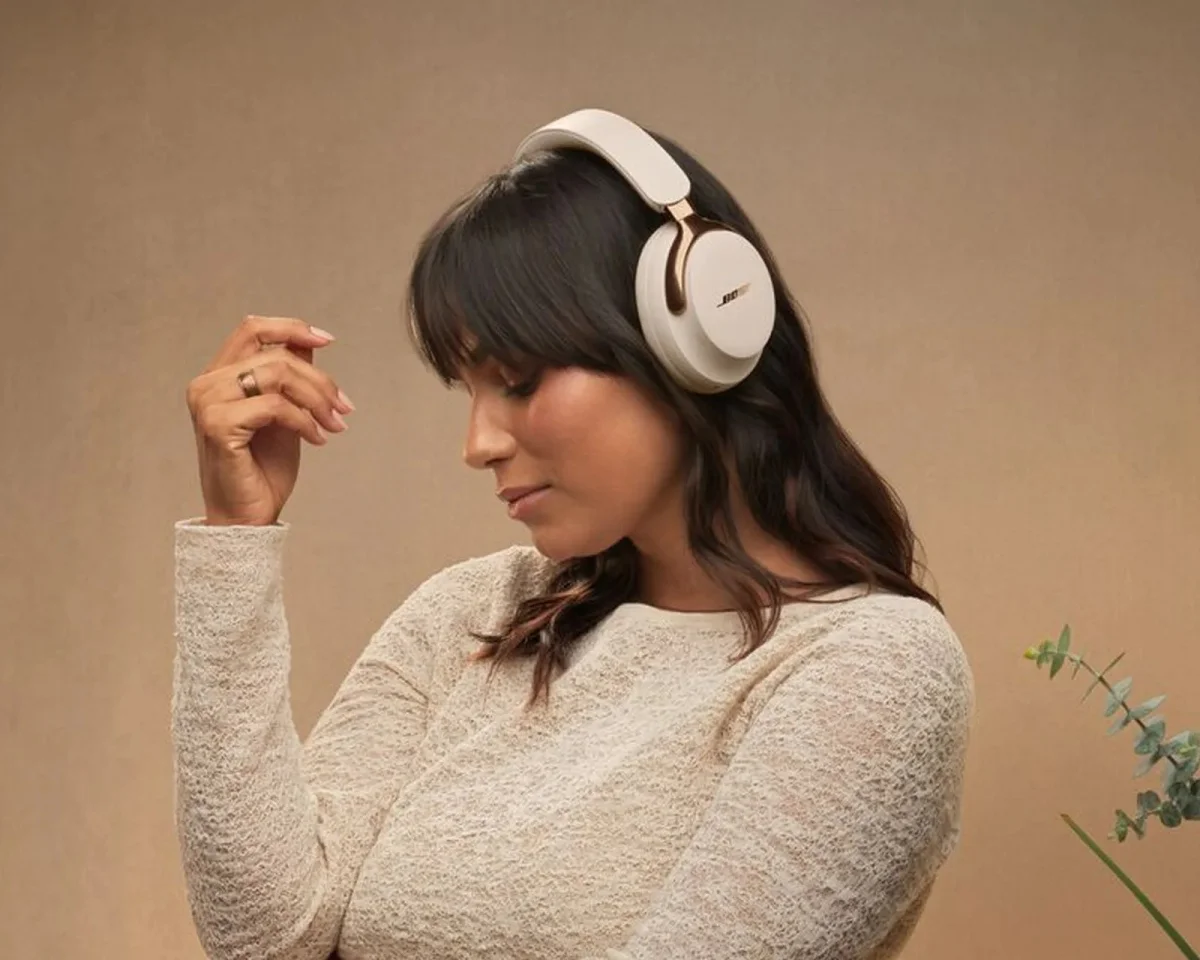 Cream-colored Bose over-ear headphones with gold accents.
