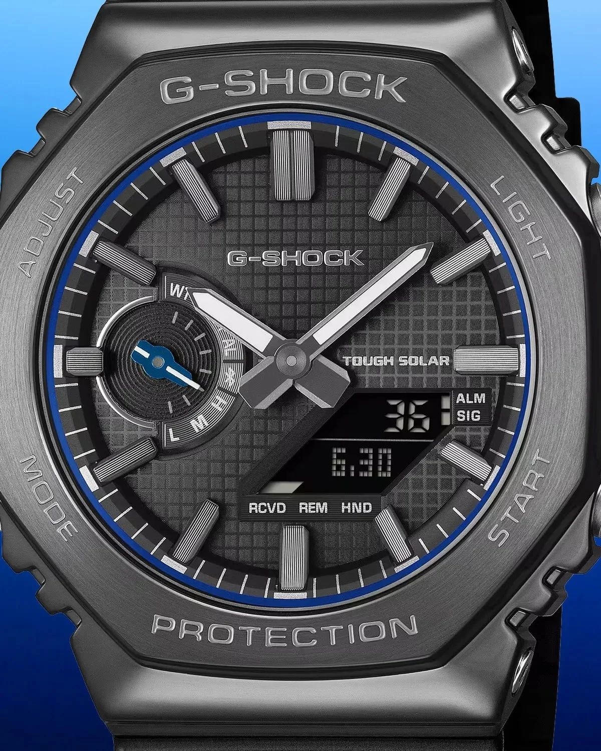 Gunmetal gray G-Shock analog-digital watch featuring a textured dark gray dial, a blue inner bezel ring, and Tough Solar branding.