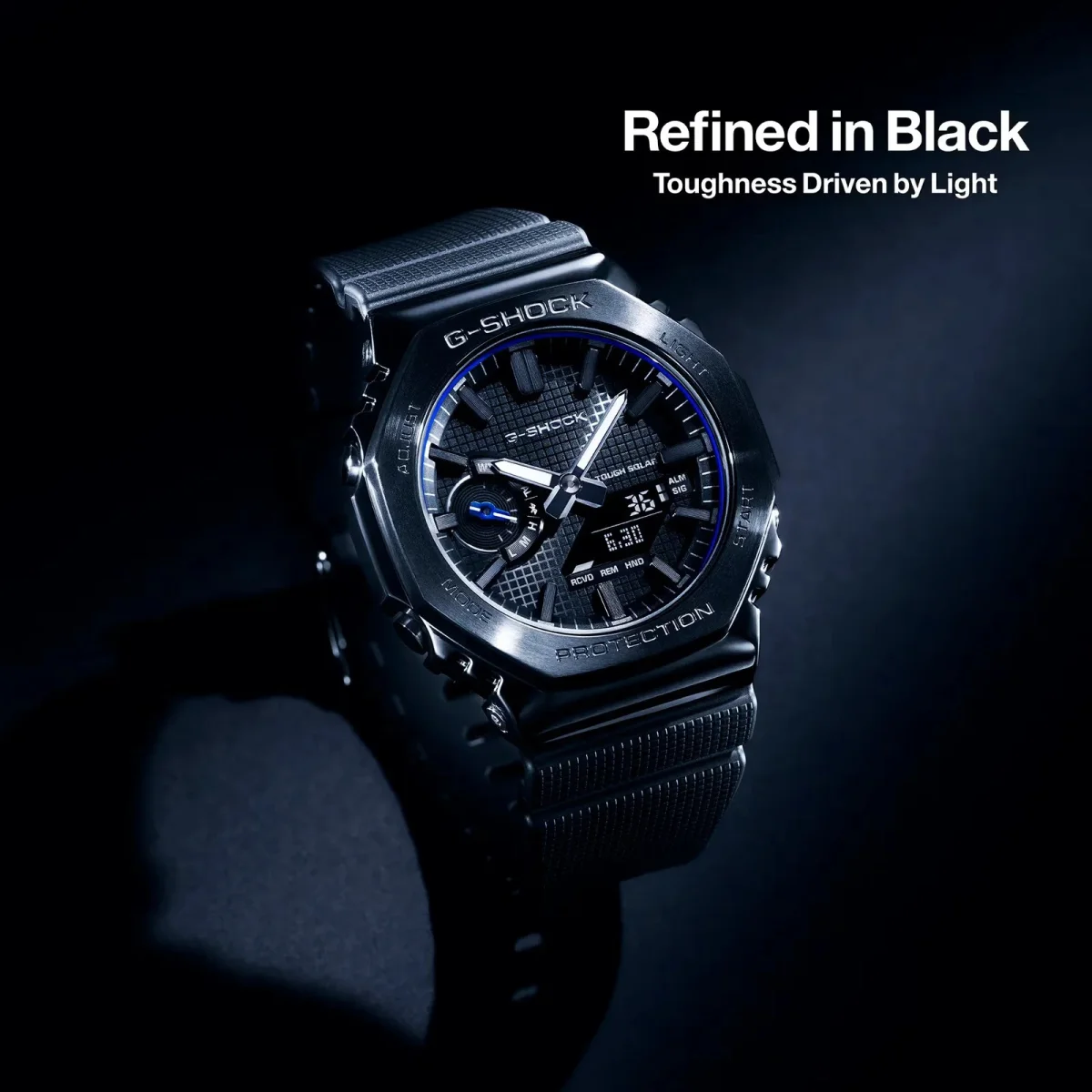 Black G-Shock watch featuring a metallic bezel and an analog-digital display, with text reading Refined in Black: Toughness Driven by Light.