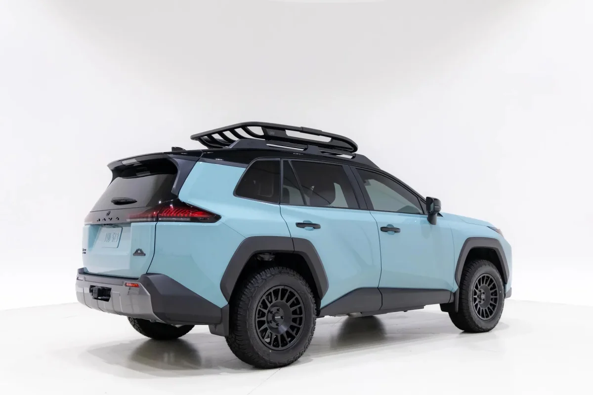 Light blue SUV with a black roof, roof rack, and black off-road wheels, viewed from the rear three-quarter angle.
