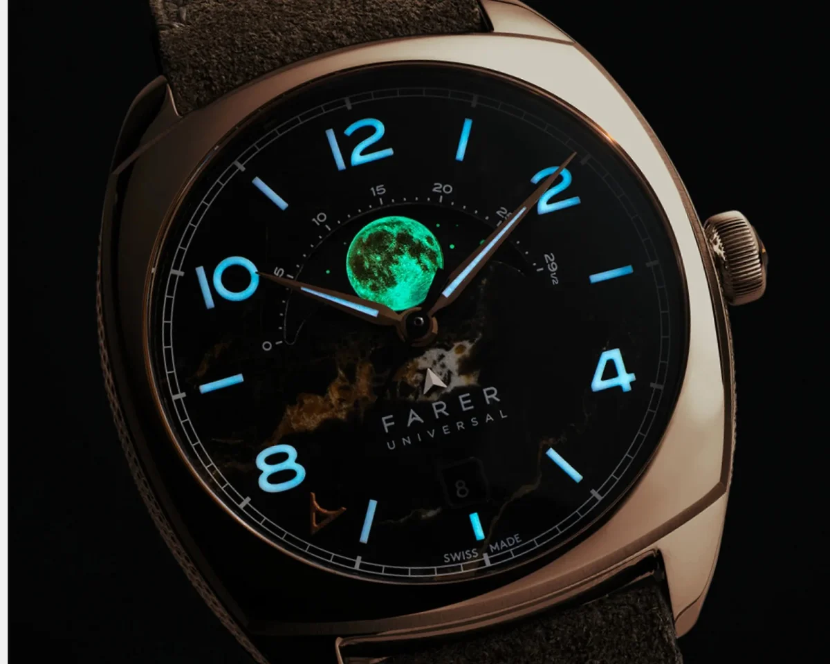 Farer Universal wristwatch featuring a black marble dial, glowing blue numerals, and a luminous green moon phase display.