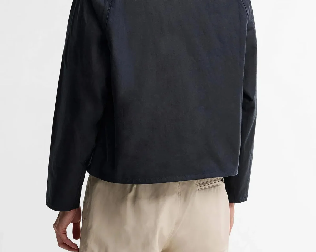 Back view of a black jacket and beige trousers.
