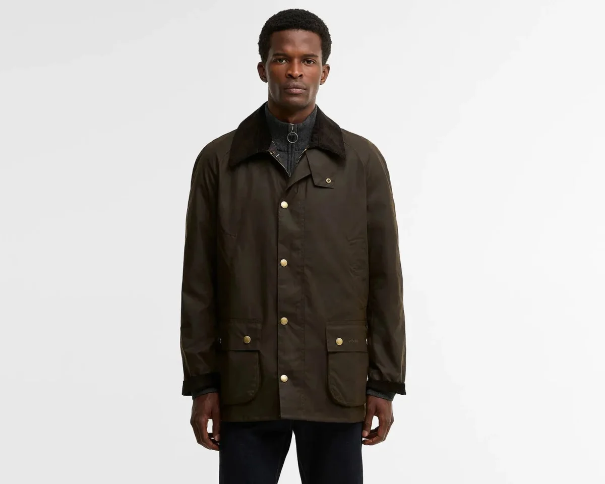 Olive green waxed cotton jacket featuring a corduroy collar and brass snap closures.