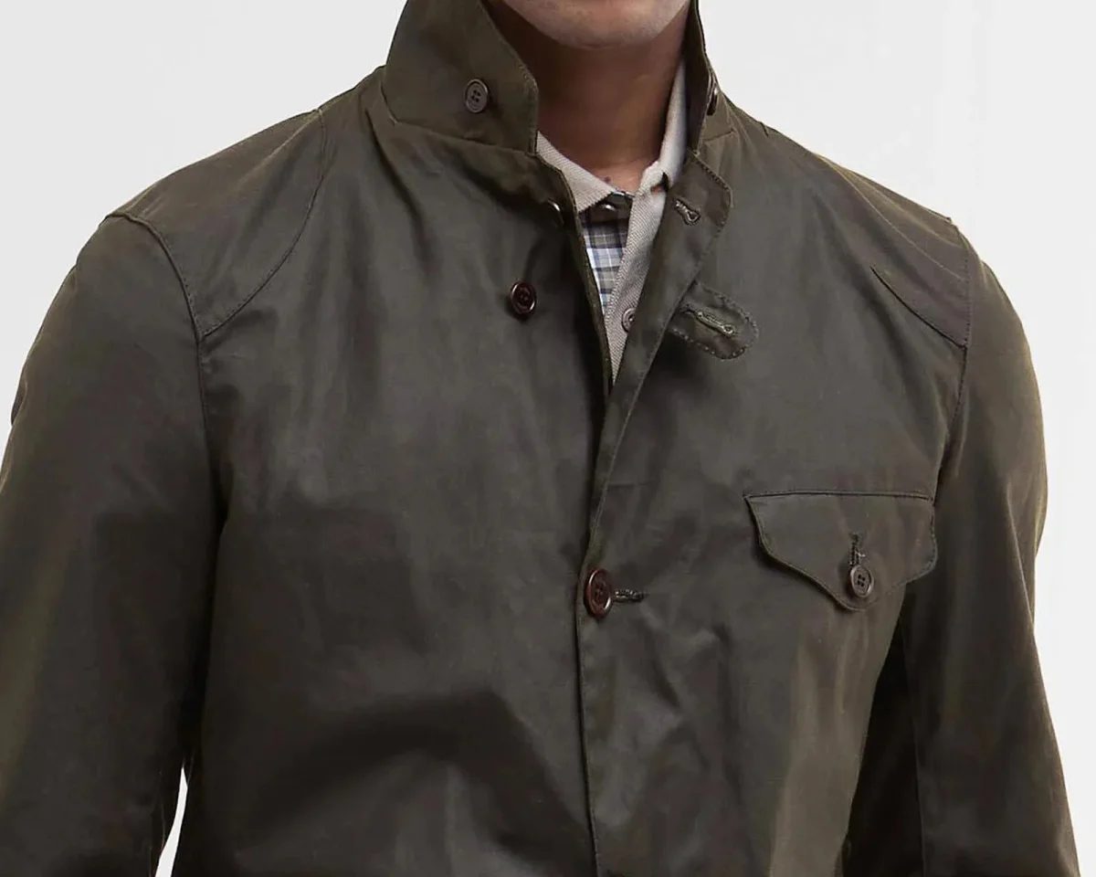 Olive green wax-finish field jacket featuring a high collar, button closure, and a single chest pocket.