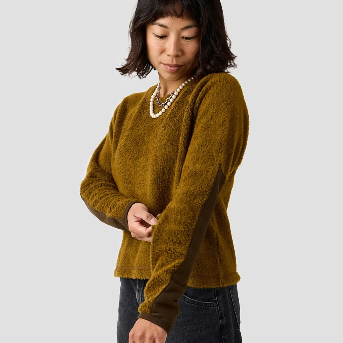 Olive green fuzzy long-sleeve sweater featuring dark brown sleeve patches.