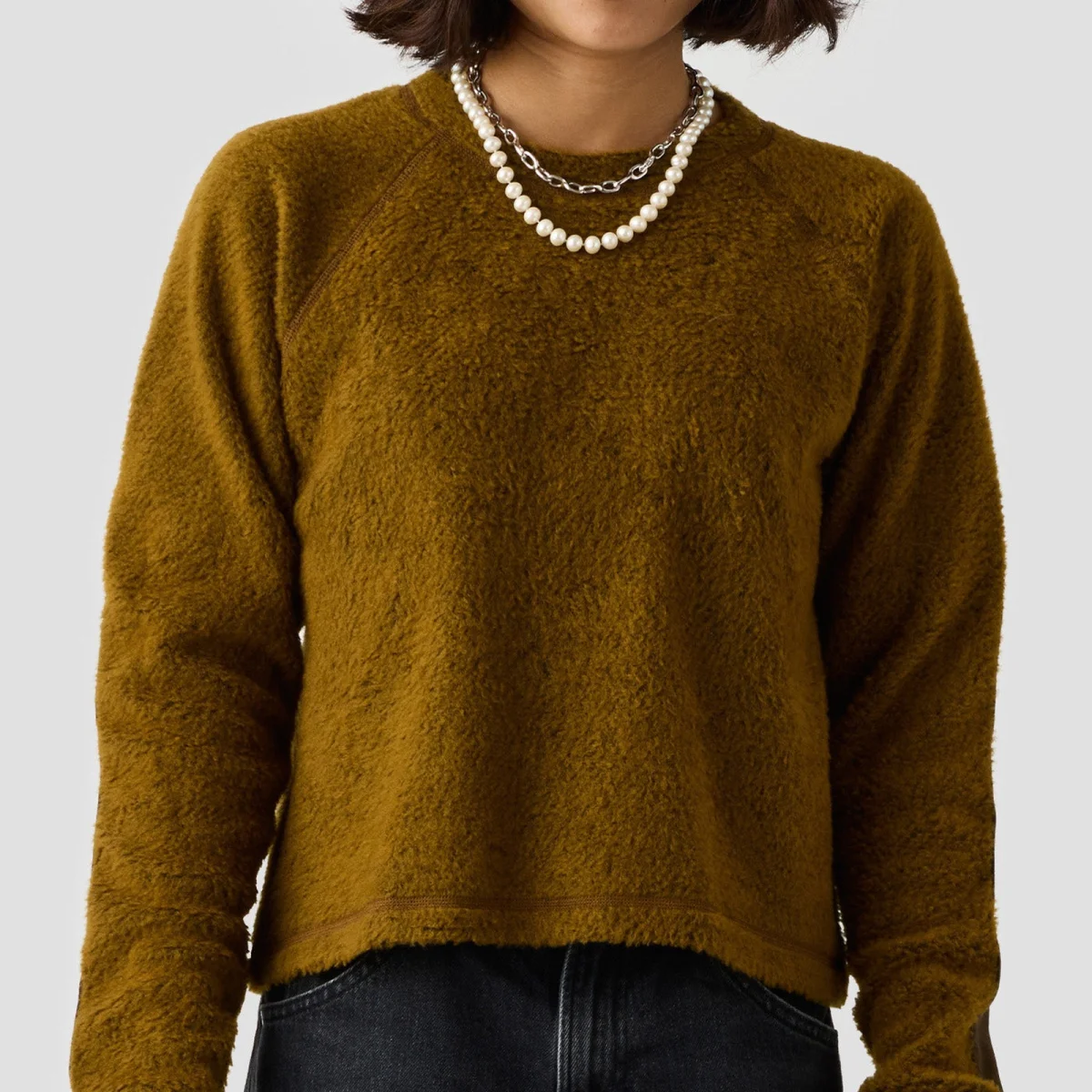 Olive green fuzzy long-sleeve sweater paired with a layered pearl and silver chain necklace.