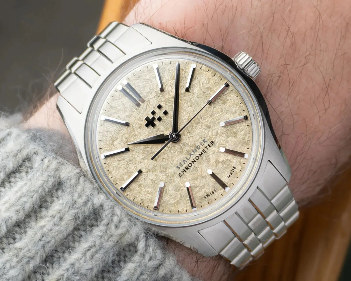 Christopher Ward Sealander Chronometer watch with a textured beige dial and a stainless steel bracelet on a wrist.
