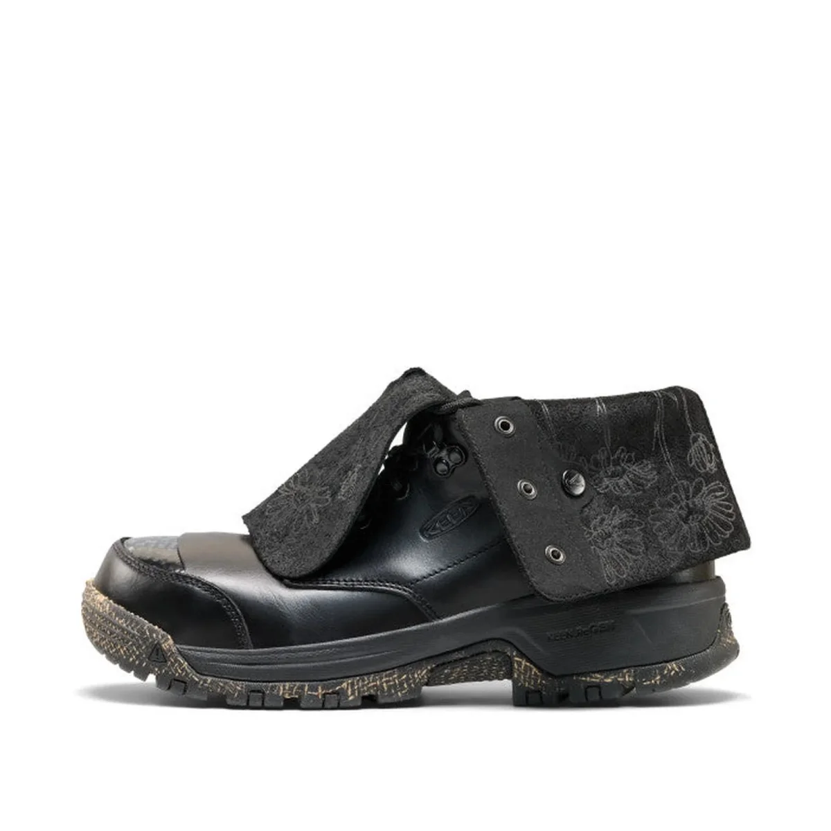 Black Keen work boot featuring a protective lace cover with a floral pattern and a lugged rubber sole.