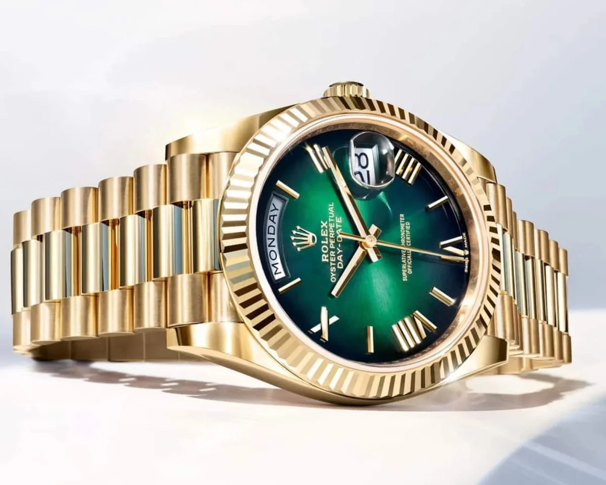 Rolex Oyster Perpetual Day-Date watch crafted in yellow gold, featuring a green dial, fluted bezel, and President bracelet.