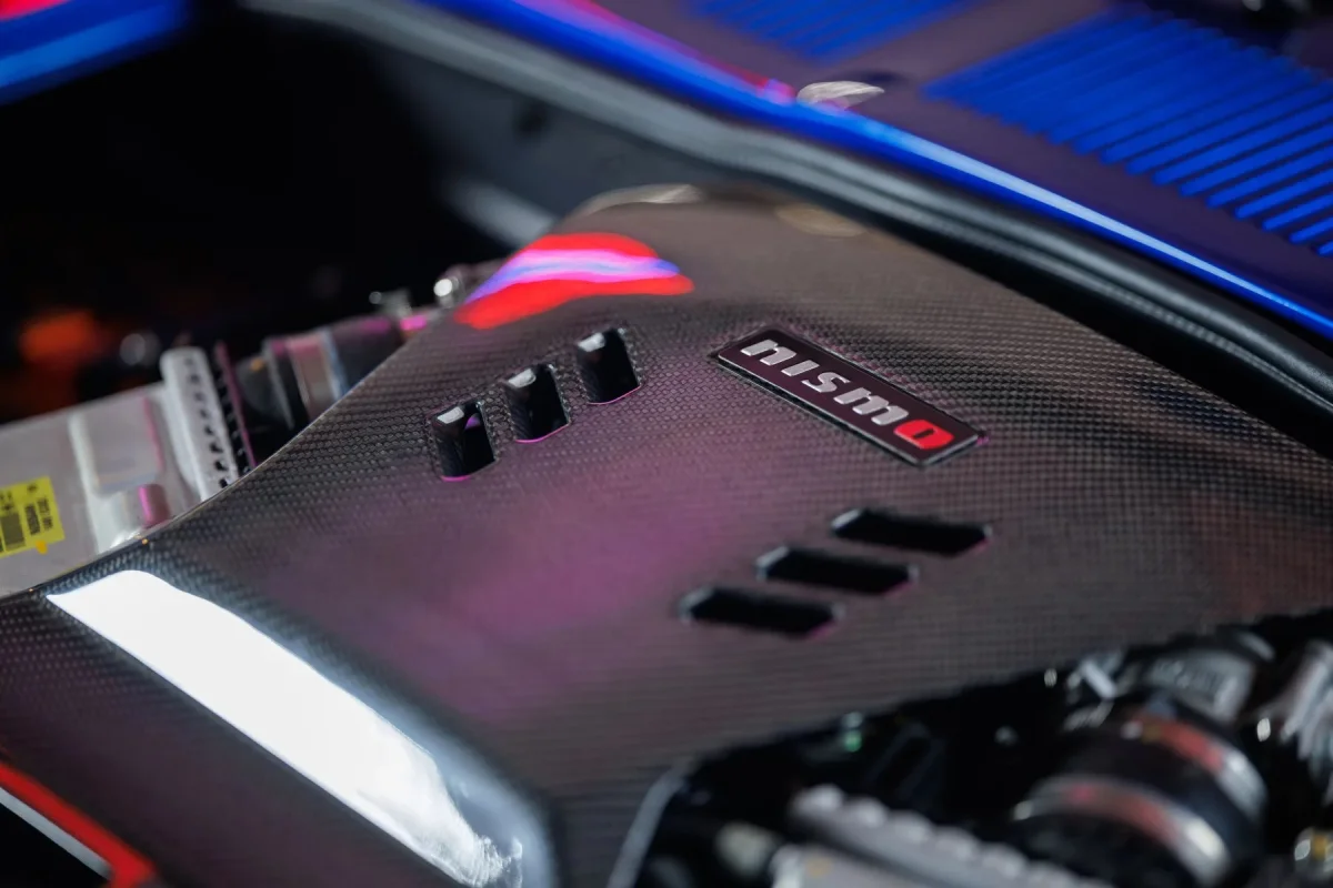 Carbon fiber engine cover featuring a Nismo emblem and integrated air vents.