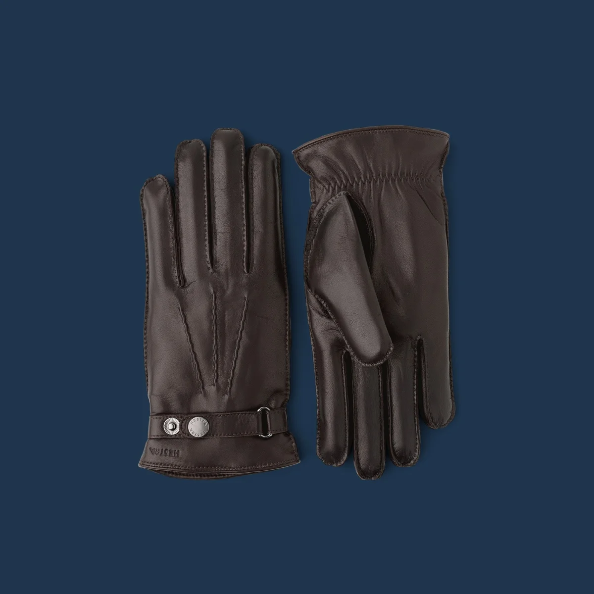 Dark brown leather gloves with silver-tone snap closures at the wrists.