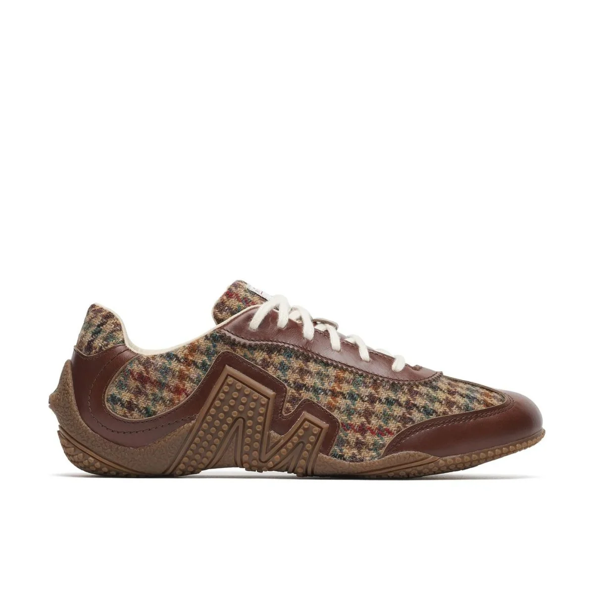 Low-top sneaker in brown leather and multicolored plaid fabric featuring white laces and a brown textured rubber sole.