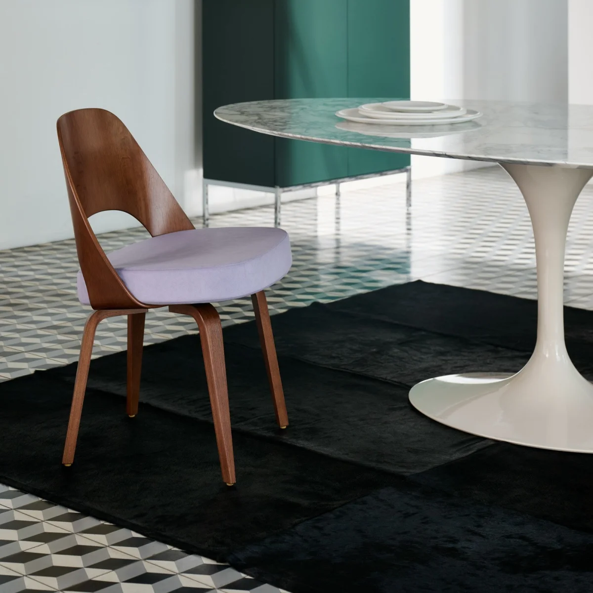 Wooden chair with curved backrest and light purple cushion next to a white marble round table with pedestal base.