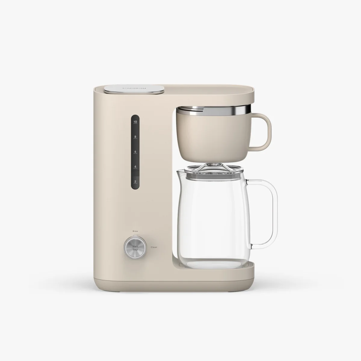 Beige modern drip coffee maker with a transparent glass carafe and a matching coffee mug placed above it on a white background.