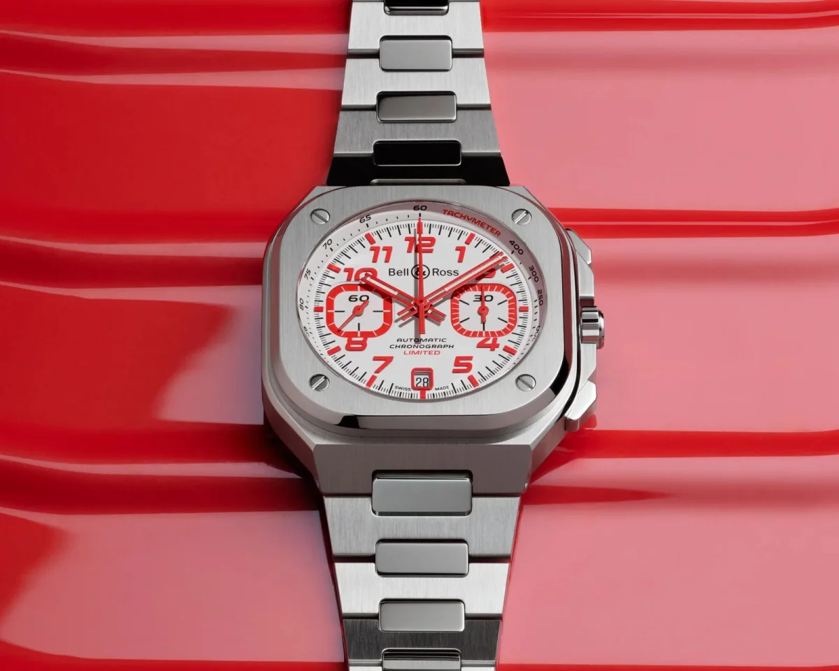 Bell & Ross square chronograph watch featuring a white dial with red numerals and hands, finished with a silver-tone metal link bracelet.