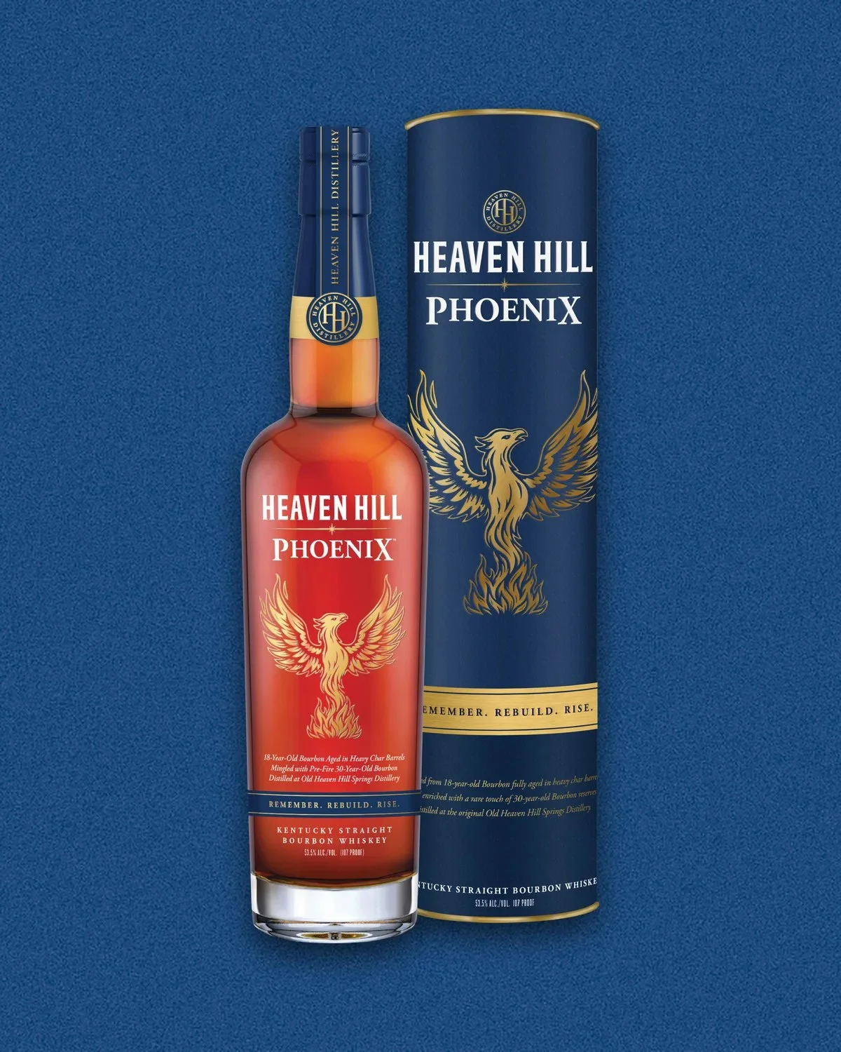 Heaven Hill Phoenix Kentucky Straight Bourbon Whiskey bottle and its matching blue cylindrical gift tube, both featuring a gold phoenix emblem and the text Remember, Rebuild, Rise.