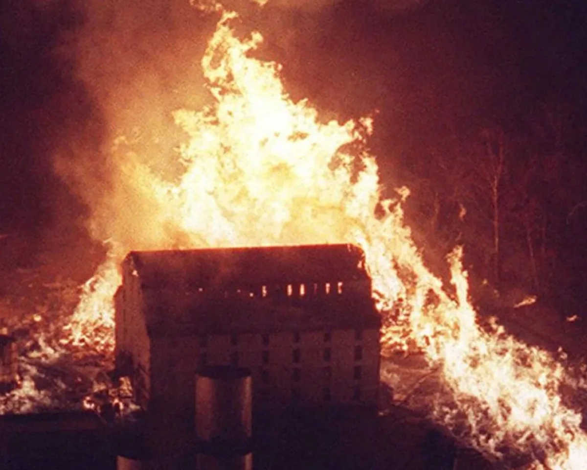 Large building engulfed in flames at night.
