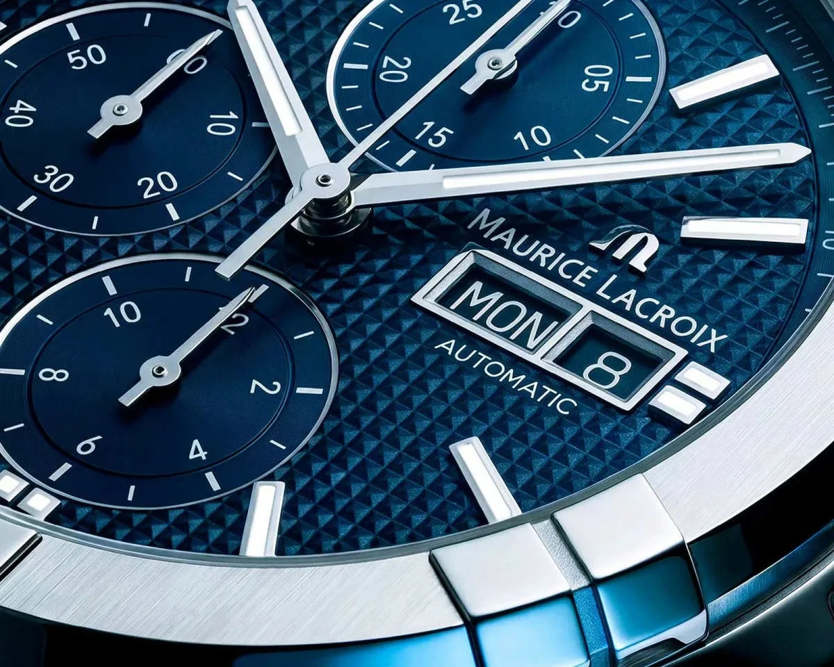 Maurice Lacroix automatic chronograph watch featuring a blue patterned dial with a day and date display at the three o’clock position.