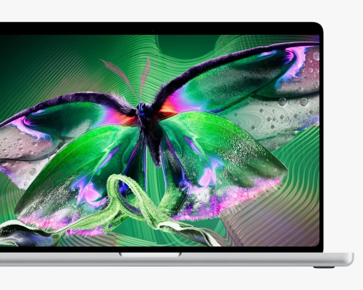 Silver laptop with a vivid green and purple butterfly wallpaper on the screen.