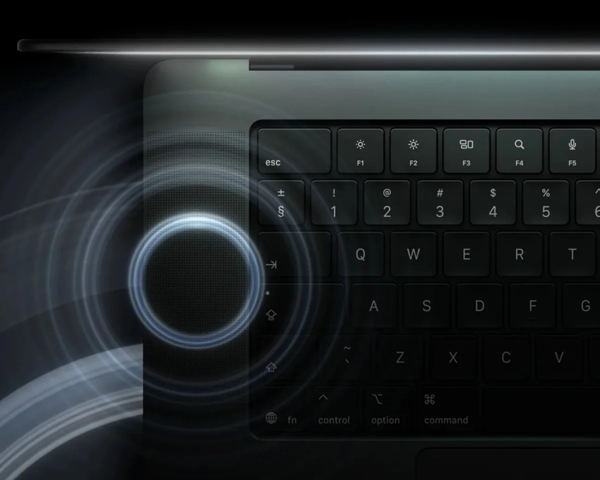 Close-up of a black laptop keyboard with a glowing circular touch control on the left side.