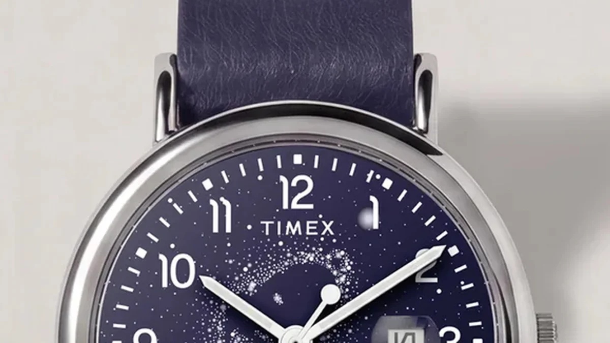 Close-up of a Timex watch with a navy blue starry dial, silver case, and dark blue leather strap.