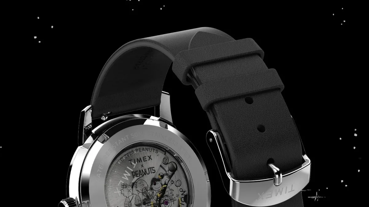 Back view of a Timex watch with a black leather strap and a transparent case back featuring Peanuts characters.