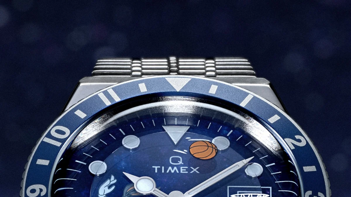 Close-up of a Timex watch with a blue bezel and dial featuring basketball and hand gesture illustrations.